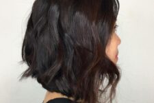 a black razor cut lob with an angle and burgundy highlights is a flattering solution that looks super nice