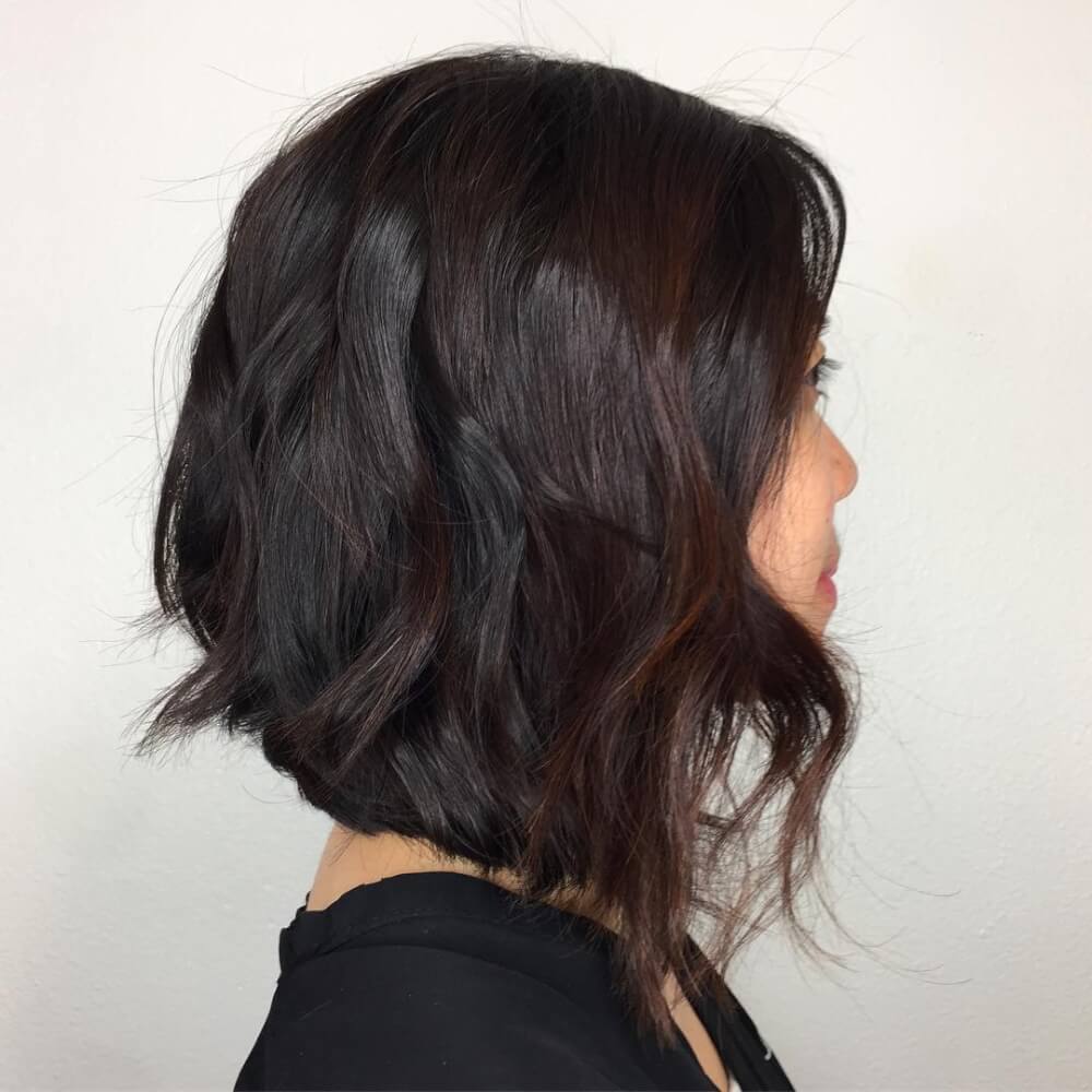 A black razor cut lob with an angle and burgundy highlights is a flattering solution that looks super nice
