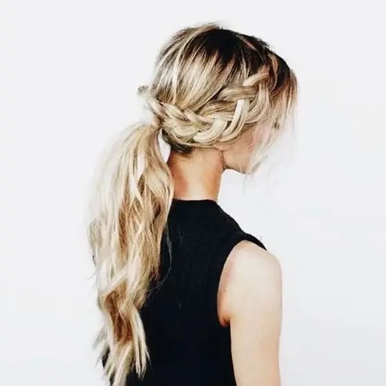 a braid going into a low ponytail with waves and locks down for a boho look