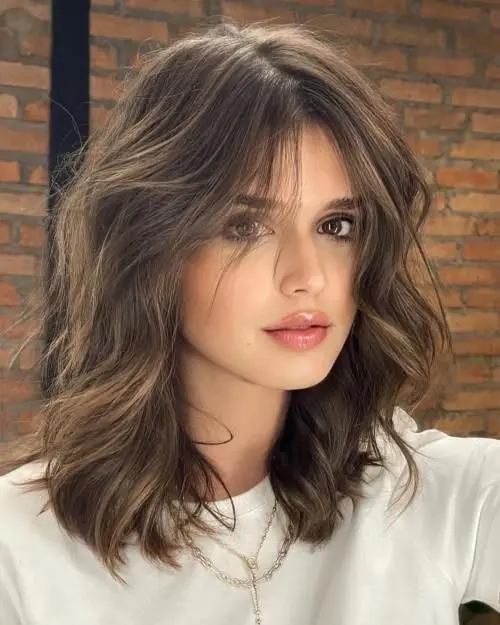 a brown medium-lenght wavy hairstyle with face-framing layers is a gorgeous idea you can try