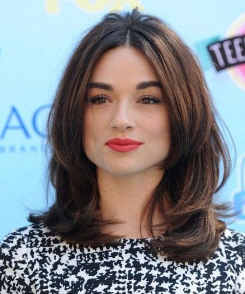 a chic brunette medium-length butterfly haircut with middle part and curved ends is a cool solution to go for