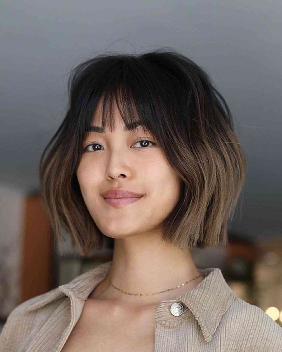 a chic chin-length layered bob with wispy bangs and an ombre effect is a bold and catchy idea