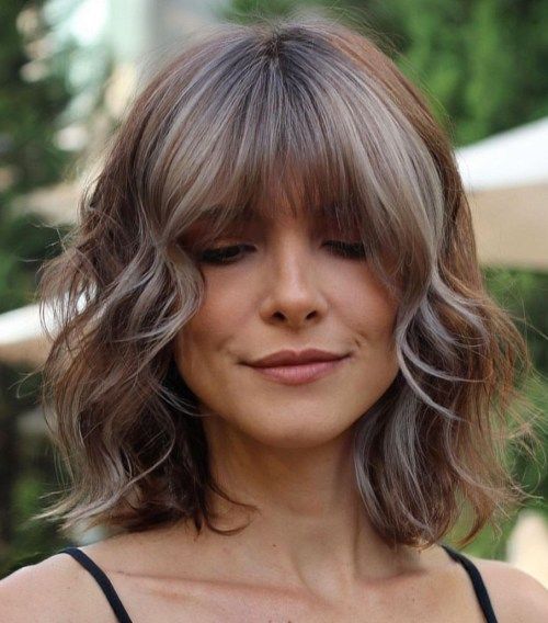 a choppy layered long bob with icy blonde highlights and wispy bangs is a catchy and bright idea to rock