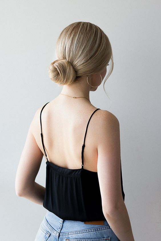 A classic twisted low bun with a sleek top and some face framing locks is a cool hairstyle to rock