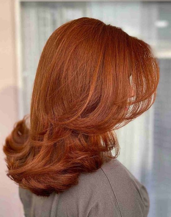 a cool and bright copper butterfly haircut on medium length hair, with curled ends is a lovely idea that looks chic