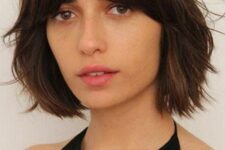 a dark brown bob with bottleneck bangs and textured shaggy hair is a cool 70s inspired idea