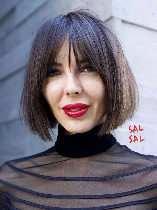 A dark brown chin length bob with wispy bangs and plenty of texture and volume is a lovely and bold idea