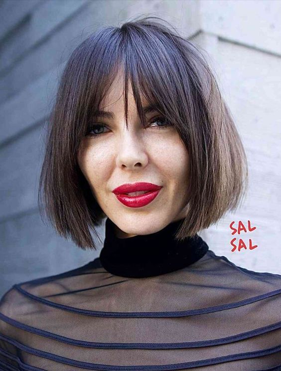 a dark-brown chin-length bob with wispy bangs and plenty of texture and volume is a lovely and bold idea