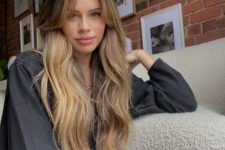 a dark root paired up with long honey blonde waves and logn curtain bangs look very girlish and very beautiful