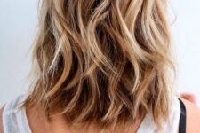 a dreamy beach hairstyle with medium-length brone hair, blonde hihglights and waves is perfect for summer