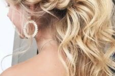 a gorgeous low wavy ponytail with a messy bump and a twisted braid on the side is a trendy idea