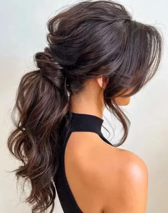 a jaw-dropping wavy messy low ponytail with a messy volume on top, locks framing the face is amazing for a glam bride
