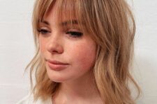 a ligth ginger long bob with messy waves and wispy bangs is a chic and refreshing idea, it catches an eye with its color