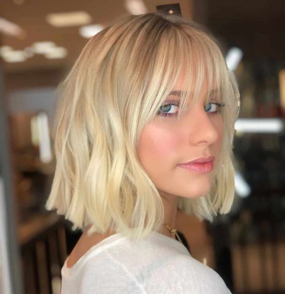 a long blonde bob with waves and wispy bangs is a bold and chic idea, you may rock it any time