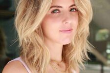 a lovely blonde shoulder-length hairstyle with a shadow root and waves, with side bangs and lots of dimension is amazing