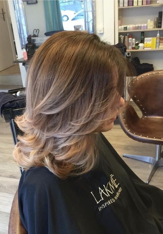 a lovely light brunette butterfly haircut of medium length, with blonde highlights and curved ends is a cool and catchy idea