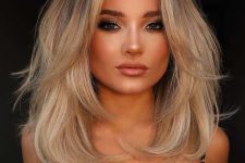 a lovely medium butterfly haircut with a darker root and wavy ends plus a lot of volume is a catchy and chic idea