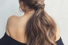 a low ponytail with a sleek top, a twisted and braided part and much dimension on the ends
