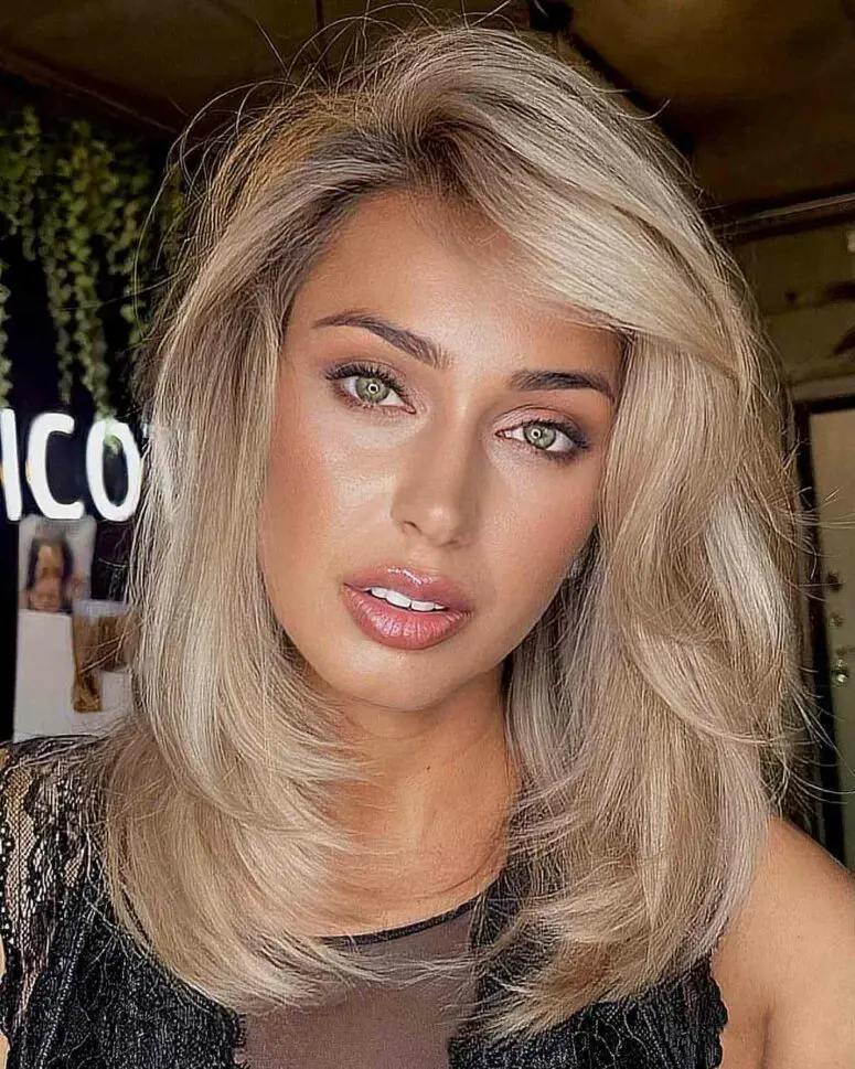 a medium blonde layered haircut with a swoop bang is a cool idea with dimension and can be very versatile