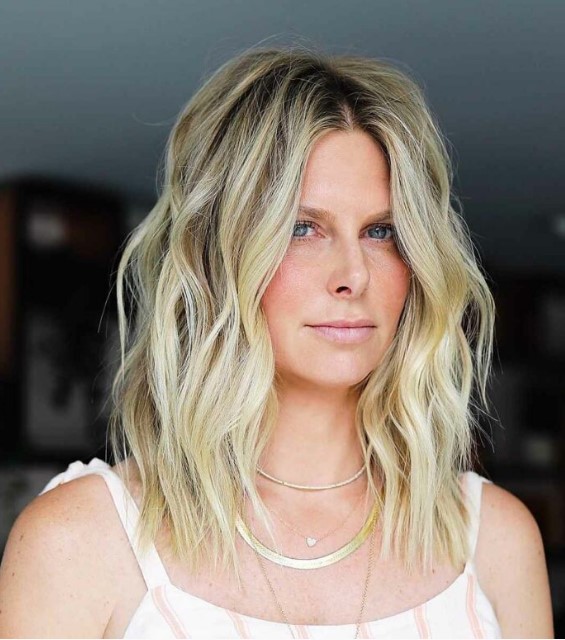 a medium layered and choppy haircut in blonde, with darker root and layers is a catchy and dimensional idea