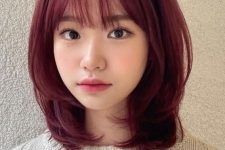 a medium length purple butterfly haircut with wispy bangs and curled ends looks super cute and delicate