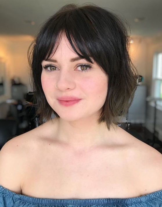 a messy and textural brown bob with layered and bottleneck bangs is a pretty and chic idea
