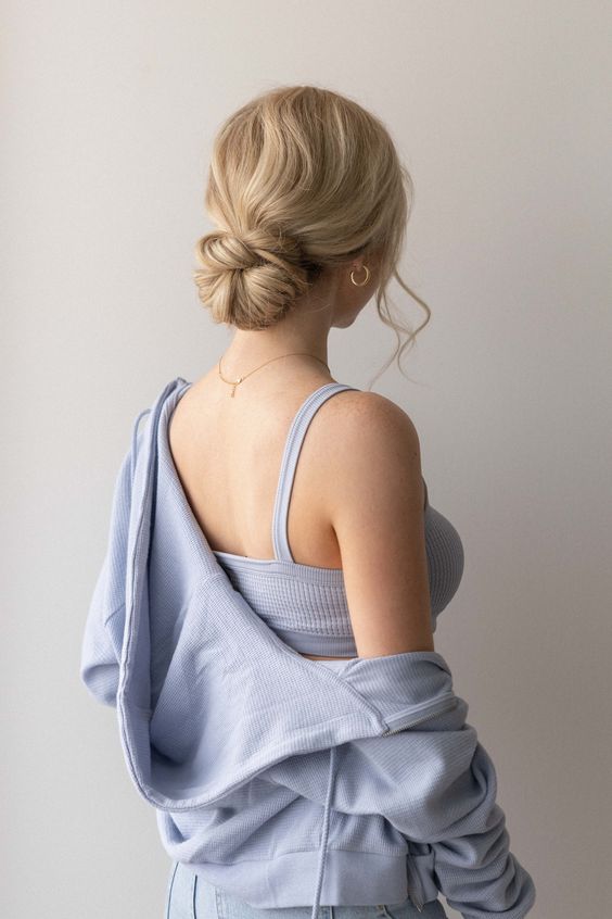 A messy wrapped low bun with a wavy top and some face framing locks is a chic and feminine solution