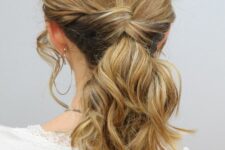 a pretty criss cross ponytail with waves and a messy wavy top plus face-framing locks is a cool idea