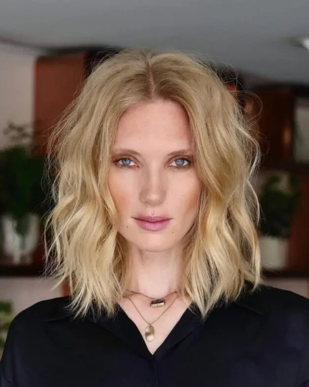 A refined blonde mid length haircut with longer layers and waves is a lovely idea if you want something edgy