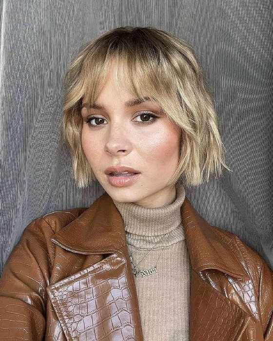 A relaxed blonde wavy jaw line bob with wispy bangs is a good idea for thin hair, it looks lovely