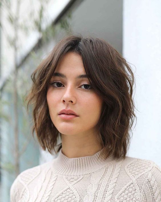 a shaggy and layered brown long bob with curtain bangs and central parting is a cool and very up-to-date idea to try right now