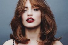 a shaggy layered medium haircut with curtain bangs and a beautiful ginger shade is an amazing solution for the fall