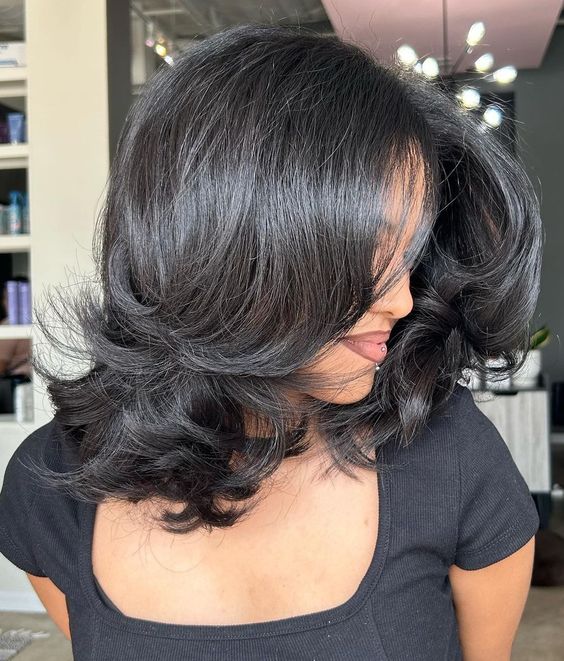 a shiny black butterfly medium haircut with curled ends is a catchy idea with a lot of volume, it looks super cool