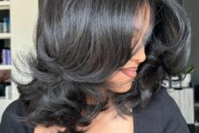 a shiny black medium-length butterfly haircut with curved ends is a gorgeous hairstyle with plenty of volume