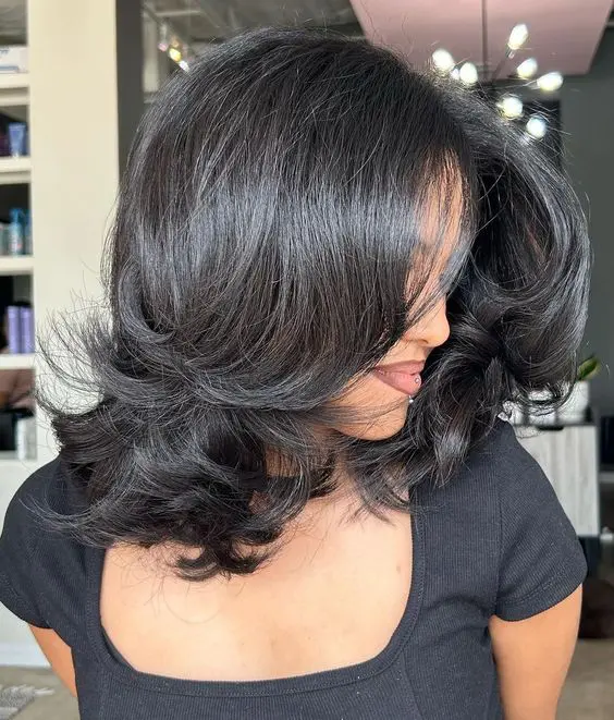 A shiny black medium length butterfly haircut with curved ends is a gorgeous hairstyle with plenty of volume