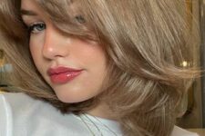 a soft blonde medium-length butterfly haircut with a lot of volume is a chic idea inspired by the 90s