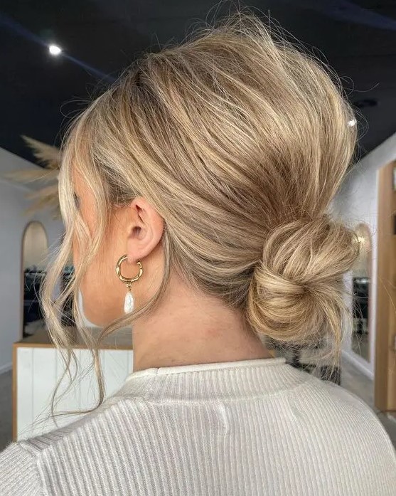 a super messy and cool low ballerina bun with a messy bump on top and face-framing locks is wow