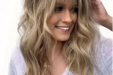 amazing long wavy londe hair with texture and with balayage plus wispy bangs for a chic touch