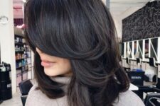 an almost black medium butterfly haircut with curved ends and a lot of volume is a chic and bold idea