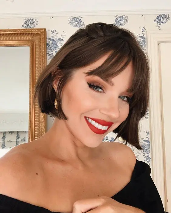 An elegant brunette jaw line bob with wispy bangs and dimension is a cool idea to rock right now