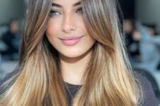 beautiful light brown long hair with an ombre blonde effect and chin bangs plus middle part looks very chic