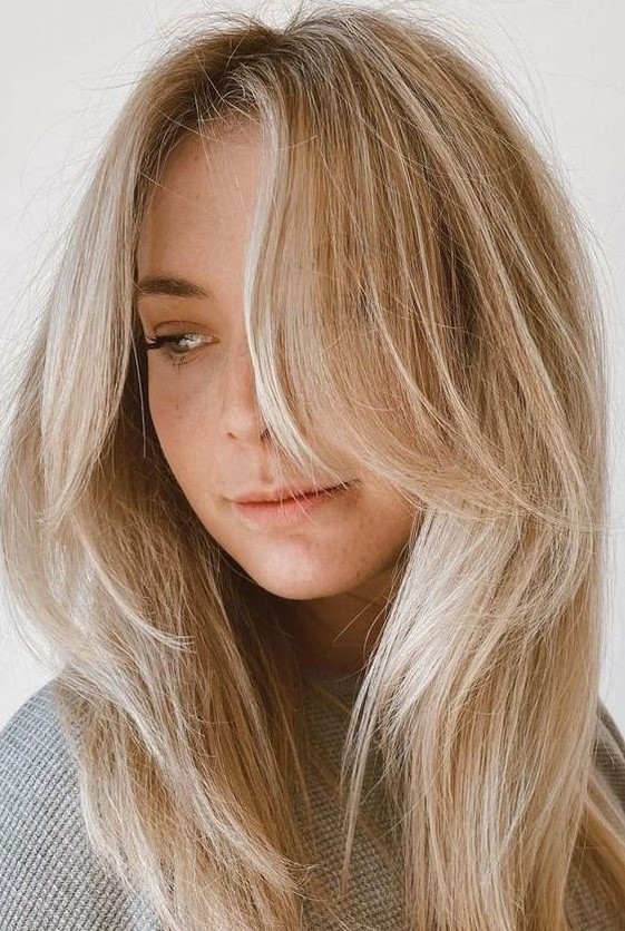 beautiful long blonde hair with icy balayage and chin-length side bangs is a chic and cool idea
