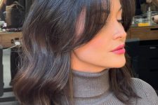 black shoulder-length hair with long curtain bangs and waves is a shiny and catchy idea