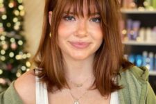 dark ginger medium-length hair with wispy bangs looks lovely and effortless and you can make a statement with color