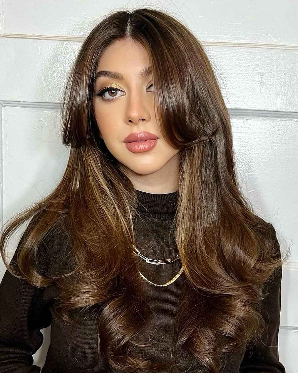 Fab long dark brown hair and central parting, curls, long face framing layers and curtains bangs that are low maintenance