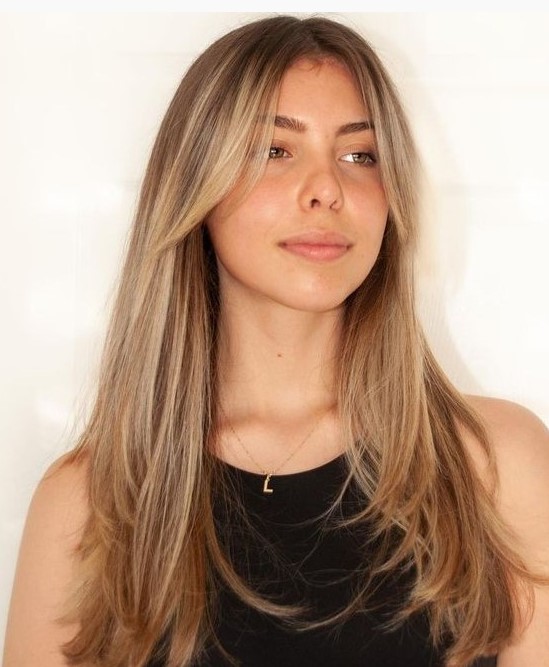 gorgeous long hair with warm blonde balayage and with curtain bangs, with much texture is a very stylish idea to rock