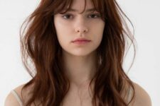 long and wavy layered cinnamon-colored hair with wispy bangs is a super cool idea to make a statement with color