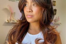 long dark hair with caramel balayage, curls and soft curtain bangs is a very stylish and chic idea to remove weight from thick hair