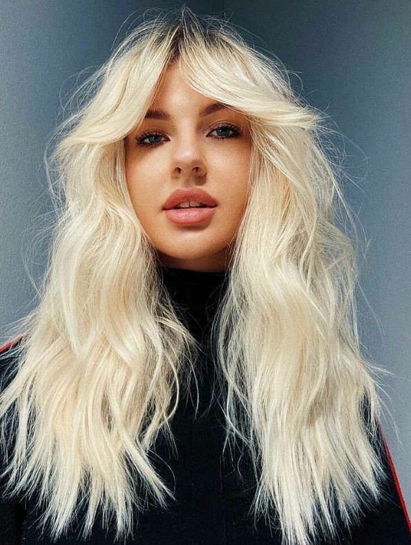 Long textural blonde hair with choppy ends and soft face framing curtain bangs is a lovely idea to try
