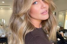 long wavy light brown hair with blonde highlights and a chunky chin-length money piece looks chic and beautiful